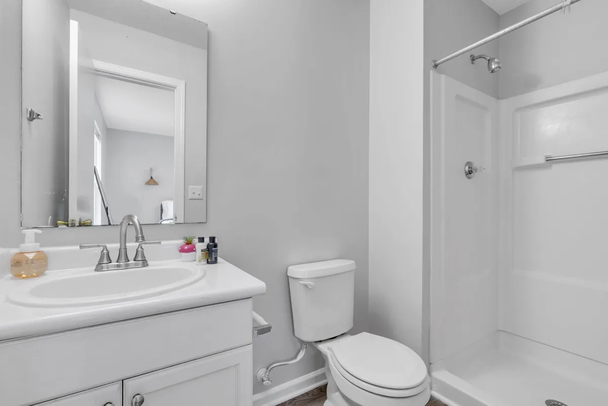 A modern bathroom with a sleek sink, large mirror, and glass-enclosed shower. The space is spotless and exudes a relaxing, rejuvenating ambiance for personal care and relaxation.